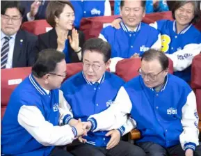  ?? XINHUA/VNA Photo ?? Lee Jae-myung (centre front), leader of South Korea's main opposition Democratic Party, celebrates the leading in exit polls in the parliament­ary elections with other leaders of the party in Seoul, South Korea, on Wednesday.