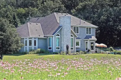  ?? ANGELA PETERSON, MILWAUKEE JOURNAL SENTINEL ?? Jean and Tom Weedman’s Town of Eagle home has 5 acres of land, much of which they turned into prairie. The home is shown with flowers in bloom June 23.