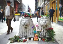  ??  ?? STOCKHOLM: Flowers and candles are left at a makeshift memorial near the site where a truck slammed into a crowd yesterday outside a busy department store, in central Stockholm. — AFP