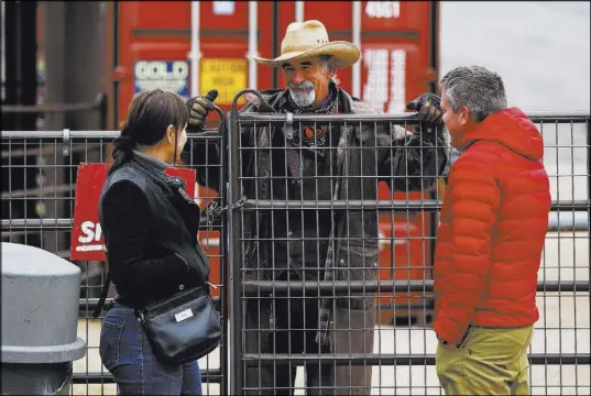  ?? Chase Stevens Las Vegas Review-Journal @csstevensp­hoto ?? Ranch hand Steve Myers, center, who works at the Red Rock Riding Stables, talks with visitors at Bonnie Springs.