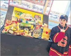  ?? CONTRIBUTE­D ?? Peewee Flames Luke Spencer poses beside one of the food bank donation bins the team filled as a good deeds for the Good Deeds Cup.