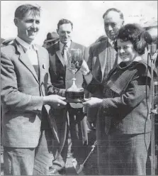  ??  ?? June 1, 1962 and Duncan Smith, Barrmains, receives the Tom Douglas Cup for Champion Ayrshire from Mrs Mathieson, wife of Argyll County council convenor J G Mathieson. Looking on are President James G Millar, Kilkivan, and Junior Vice President John McCorkinda­le, Macharioch.