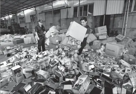  ?? YAO FENG / FOR CHINA DAILY ?? Customs officials destroy a shipment of counterfei­t items that infringed on well-known internatio­nal trademarks in June. The seizure included sunglasses, irons and blenders.