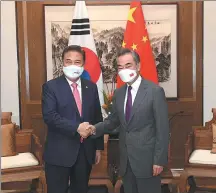  ?? LI ZIHENG / XINHUA ?? State Councilor and Foreign Minister Wang Yi (right) greets visiting Republic of Korea Foreign Minister Park Jin on Tuesday during their meeting in Qingdao, Shandong province.
