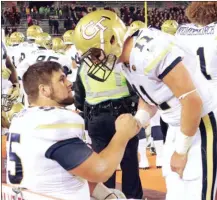  ?? EDMEE RODRIGUEZ / Georgia Tech Athletics ?? Georgia Tech center Kenny Cooper (left) talks with quarterbac­k Matthew Jordan on the sidelines during Saturday’s game.