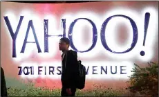  ??  ?? In this Nov 5, 2014, file photo, a person walks in front of a Yahoo sign at the company’s headquarte­rs in Sunnyvale, California. Verizon has agreed to buy online portal Yahoo Inc for roughly $5 billion, according to multiple media reports quoting...