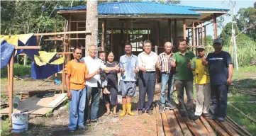  ??  ?? Ten (centre) with (from third left) Julia, Seo and other local community leaders and workers in front of Seo’s new house, which is still under constructi­on.