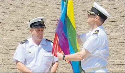  ?? MITCH MACDONALD/THE GUARDIAN ?? HMCS Queen Charlotte coxswain and chief petty officer 2nd class Chris Watt, from left, raises the pride flag with padre Greg Davis during a formal ceremony at the ship on Sunday afternoon. The ceremony marked the first time the rainbow pride flag has...