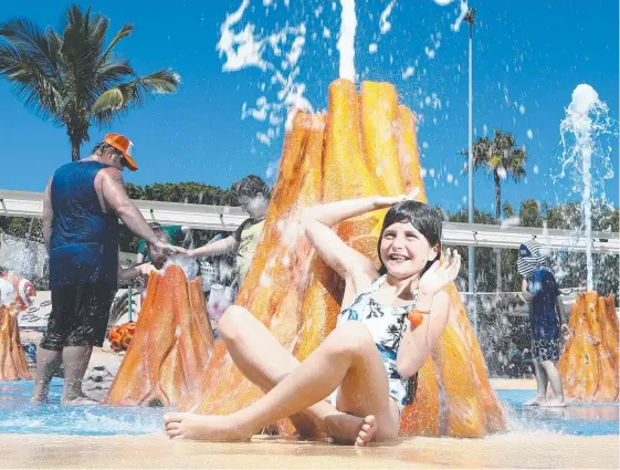  ?? Picture: GLENN HAMPSON ?? English visitor Phoebe Reid, 9, cools off splashing around the new Castaway water play area at Seaworld, as are many others to beat the heat.