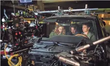  ??  ?? Director Edgar Wright, center, works on interior car shots with Lily James and Elgort on set in the “biscuit” rig.