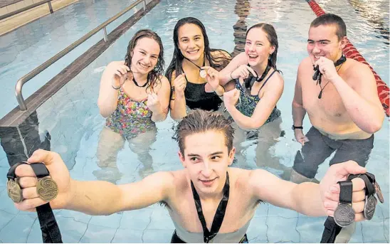  ?? Photo / Paul Taylor ?? Jake Stephens (front) and (from left) Alena Kamper, Mahina Ross, Arabella Smith and Lance Dustow are in celebratio­n mode with their medal haul from the New Zealand Secondary School Swimming Champs in Wellington.