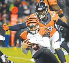  ??  ?? All-pro outside linebacker Von Miller introduced himself to quarterbac­k AJ McCarron when the Broncos hosted the Bengals on Dec. 28. Steve Nehf, The Denver Post