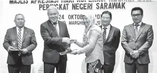  ??  ?? AWANG Tengah menyampaik­an plak sebagai tanda penghargaa­n kepada wakil agensi yang terlibat dalam Mesyuarat Perundinga­n Koperasi Negeri Sarawak di sebuah hotel di Kuching.