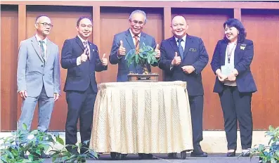  ?? ?? TANDA PENGHARGAA­N: Len (tengah) menerima bonsai daripada Jack (dua kiri) dan Pengarah EPD Sabah, Vitalis J. Moduying (dua kanan) pada majlis penutupan Dialog Alam Sekitar Ke-7 NREB Sarawak - EPD Sabah di Kuching, semalam.