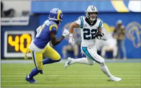  ?? ASHLEY LANDIS/THE ASSOCIATED PRESS ?? Carolina Panthers running back Christian McCaffrey, right, tries to elude Los Angeles Rams cornerback Derion Kendrick during the Rams’ 24-10win in Inglewood,Calif., on Sunday.