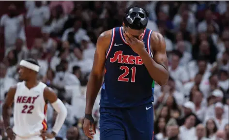  ?? WILFREDO LEE — THE ASSOCIATED PRESS ?? Sixers center Joel Embiid, right, wipes his face during the second half of Game 5Tuesday night in Miami. The Heat would win going away, 120-85.