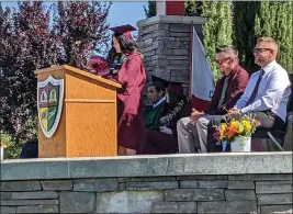  ?? PHOTOS BY JENNIE BLEVINS — ENTERPRISE-RECORD ?? Student speaker and Fairview High School graduate Emily Olivarez proudly speaks to parents, other family members, administra­tion, her fellow graduates and community members at the Fairview High School and Oakdale School graduation ceremony Thursday at DeGarmo Park in Chico.