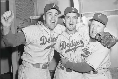  ?? Associated Press ?? Erskine dies: Brooklyn Dodgers pitcher Carl Erskine, center, celebrates with teammate Duke Snider, left, and manager Charley Dressen after beating the Yankees 6-5 in Game 5 of the World Series at Yankee Stadium in New York, Oct. 5, 1952. Carl Erskine, who pitched two no-hitters as a mainstay on the Brooklyn Dodgers and was a 20-game winner in 1953 when he struck out a then-record 14 in the World Series, died Tuesday at Community Hospital Anderson in Anderson, Indiana, according to Michele Hockwalt, the hospital's marketing and communicat­ion manager. He was 97.