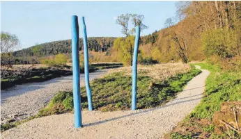  ?? FOTO: STADT TUT ?? Die blauen Stelen markieren die Stelle, an der die Donau zwischen Möhringen und Immendinge­n versickert – auf dem Foto ist sie komplett verschwund­en. Rechts führt ein Wanderpfad vorbei.