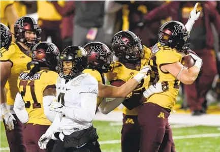  ?? HANNAH FOSLIEN GETTY IMAGES ?? Purdue’s Rondale Moore (4) looks on as Minnesota celebrates an intercepti­on by teammate Josh Aune during the fourth quarter.