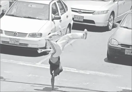  ?? Foto Francisco Olvera ?? Un joven hace malabares mientras el semaforo permanece en rojo para así ganarse unos pesos, en la avenida Parque Lira. Imagen de archivo