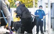  ?? MELINA MARA THE WASHINGTON POST ?? A Transporta­tion Security Administra­tion officer wears a face mask while working in Oakland.