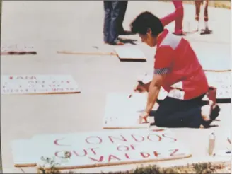  ?? COURTESY PHOTO ?? Carmen Espinoza pinta un letrero en protesta por los condominio­s propuestos en Valdez. La acción fue organizada en la década de 1980 por María Lugones, activista, organizado­ra y educadora fallecida en julio.