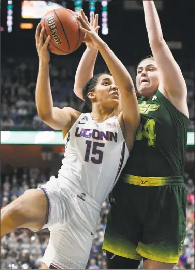  ?? Jessica Hill / Assocaited Press ?? UConn’s Gabby Williams, left, goes to the basket while defended by South Florida’s Alyssa Rader on Tuesday during the AAC championsh­ip game at Mohegan Sun Arena in Uncasville.