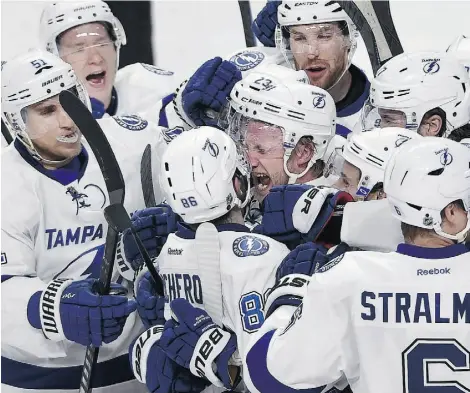  ?? THE CANADIAN PRESS/ Ryan Remiorz ?? Lightning right winger Nikita Kucherov is surrounded by teammates as he celebrates after scoring the winning goal during the second overtime period against the Canadiens in Game 1 of their second-round playoff series Friday.