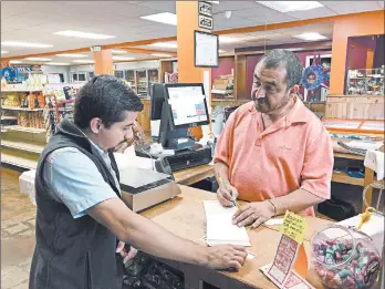  ?? JEFF AMY/AP ?? Juan Garcia, right, waits on a customer at his business, Hondumex, in downtown Morton, Mississipp­i, on Thursday.