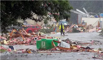 ?? AP Photo/Butch Dill ?? A police officer stands guard after a possible tornado touched down destroying several businesses Thursday in Fairfield, Ala. Alabama Gov. Kay Ivey says the threat of severe weather has not concluded as the remnants of Tropical Storm Cindy pushes...