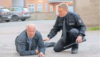  ?? FOTO: NDR ?? Nach einem Brand in seiner Wohnung schleppt sich Borowski (Axel Milberg, l.) auf die Straße. Die Kollegen tippen auf einen Molotow-Cocktail, den jemand in seine Wohnung geworfen hat.