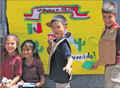  ?? Courtesy photo ?? Albert Einstein Academy of Letters, Arts and Sciences’ Elementary School students pose in front of a poster for Mexico as part of the school’s first World Culture Day on Wednesday.