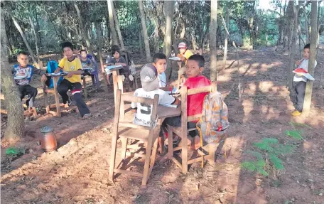  ?? ?? Los niños de la comunidad indígena de La Paloma del distrito de Yataity del Norte dan clases bajo árboles.