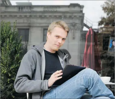  ?? GERRY KAHRMANN / PNG ?? Morten Rand- Hendriksen uses his tablet computer at an outdoor café. He built a homemade antenna for use at home.