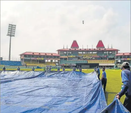  ?? PTI ?? Ground staff drag covers onto the field at the HPCA stadium in Dharamsala in anticipati­on of rain, ahead of the first T20I against South Africa on Saturday.
