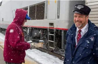  ?? Three photos, Bob Johnston ?? Conductor Brad Swartzwelt­er brings coffee to engineer L.C. Owen as the eastbound California Zephyr stops at Fraser-Winter Park, Colo.