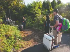  ?? GEOFF ROBINS / AFP VIA GETTY IMAGES FILES ?? Migrants prepare to cross into Canada illegally at the Quebec border in 2017. Prime Minister Justin Trudeau hopes to attract 421,000 newcomers by 2023.