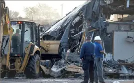  ?? Darrell Sapp/ Post- Gazette ?? A crew works to demolish Churchill Center on Monday after a fire destroyed the Penn Hills shopping plaza the previous night.