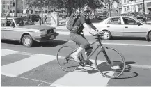  ??  ?? A cyclist rides in a bike lane along Johnson Street, well separated from vehicles.