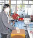  ??  ?? Ein Wähler wirft seinen Stimmzette­l im Foyer der Donauhalle in die Wahlurne.