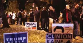  ?? ALEX WONG/GETTY IMAGES/AFP ?? Voters wait in line for casting their ballots outside a polling place on Election Day yesterday in Alexandria, Virginia.