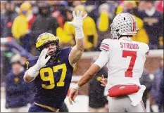  ?? Carlos Osorio / Associated Press ?? Michigan defensive end Aidan Hutchinson (97) rushes Ohio State quarterbac­k C.J. Stroud (7) during the first half of an NCAA college football game on Nov. 27 in Ann Arbor, Mich.