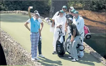  ?? GETTY IMAGES ?? From left, Ian Poulter, Henrik Stenson, Matt Wallace and Max Homa and their caddies pose for a photo on the Hogan Bridge during a practice round for the Masters on Wednesday.