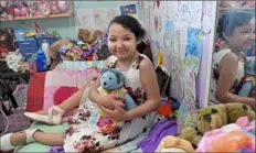  ?? Matt Freed/Post-Gazette ?? Kendra Acosta, 10, along with her doll, Blueberry, sits on her bed surrounded by her art Friday in Penn Hills. Kendra received a multi-organ transplant in February.