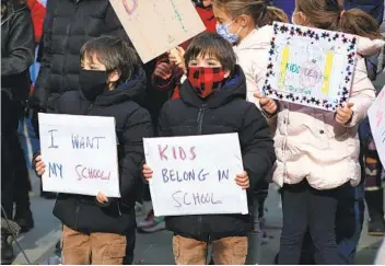  ?? KENA BETANCUR AFP VIA GETTY IMAGES ?? Children take part in a protest demanding that public schools remain open in New York in November. Experts say children will likely have to wait months longer than adults to get vaccinated.