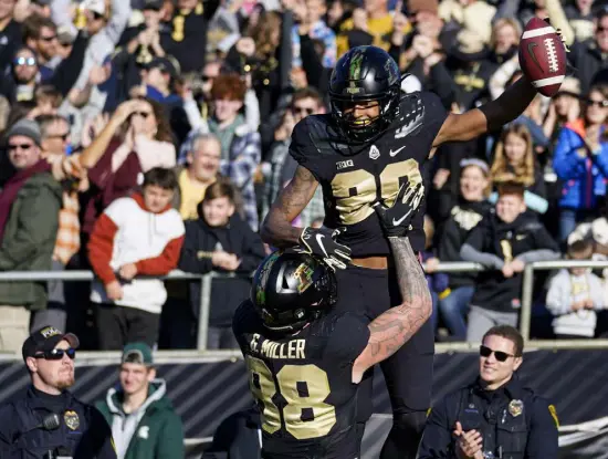  ?? Michael Conroy,the Associated Press ?? Purdue wide receiver Broc Thompson (29) celebrates a touchdown in the arms of tight end Garrett Miller (88) during the first half Saturday against Michigan State in West Lafayette, Ind.
