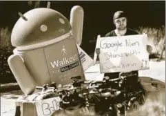 ?? REUTERS ?? A Google employee holds a sign next to an Android mascot during a protest over the handling of sexual misconduct at the company in California