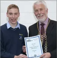  ??  ?? Rory Cassidy receiving the Award for Achievemen­t in Journalism from Cllr Jim Moore.