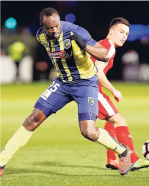  ??  ?? Usain Bolt (foreground) overruns the ball during a friendly trial match between the Central Coast Mariners and the Central Coast Select in Gosford, Australia, on Friday, August 31, 2018. Bolt scored a brace in his most recent game for the Mariners.